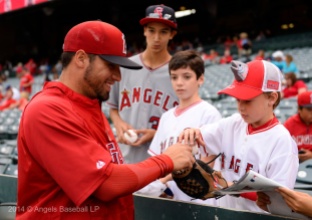 Hector Santiago smiling signing autographs for fans young fan